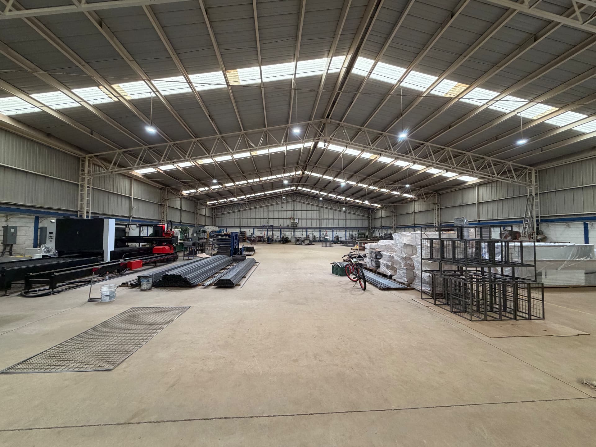 Nave principal de ARANSA con equipo de corte láser CNC, perfil tubular y producto empacado