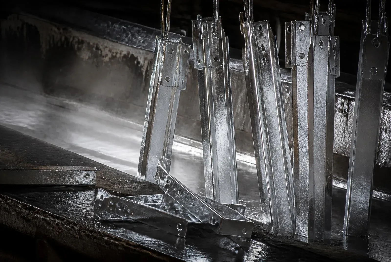 Piezas de acero recién galvanizadas saliendo del baño de zinc