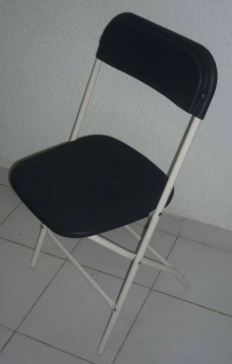 Silla plegable de acero fabricado por ARANSA — Estructura pintada y asiento tapizado en color.