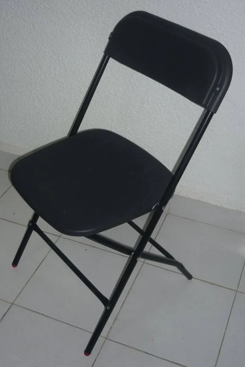 Silla plegable de acero fabricado por ARANSA — Estructura pintada y asiento tapizado en color.