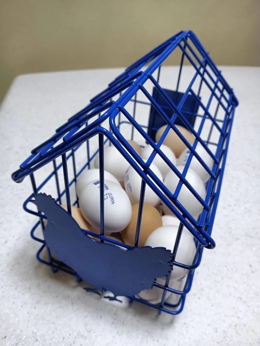 Canasta huevera de acero fabricado por ARANSA — Diseño tipo casa con figura calada en lámina y marca del cliente.